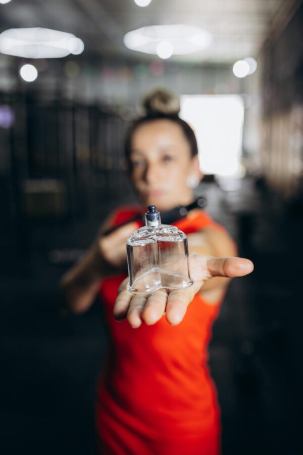 A woman holding a perfume bottle in her hand